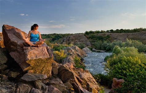 Woman Meditating On A Rock Above A River Stock Image Colourbox