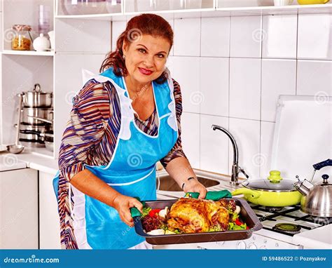Mujer Madura Que Prepara El Pollo En La Cocina Foto De Archivo Imagen De Desayuno Alimento