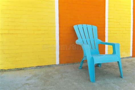 Blue Chair In Front Of A Colorful Brick Wall Stock Image Image Of