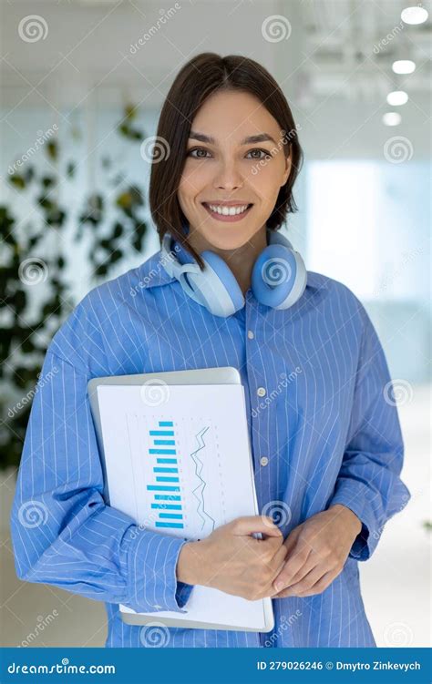 Happy Female Office Worker With Papers And The Laptop Looking Ahead