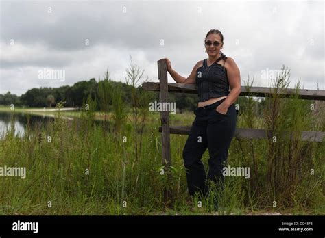 A Pretty Female Posing Against A Wooden Fence With Mill Dam Lake In