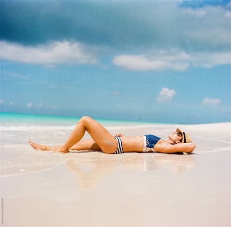 Beautiful Woman In A Bikini Laying On A Beach Stocksy United