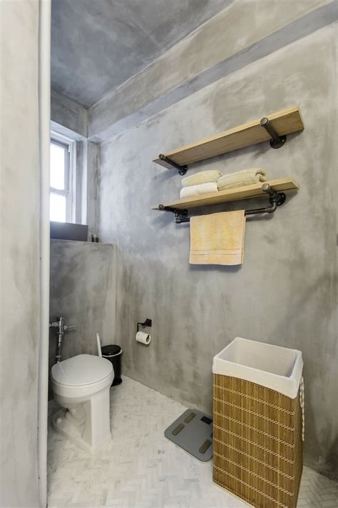 A Bathroom Renovation With Concrete Walls And Marble Finishes