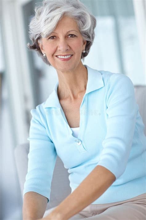 portrait of happy senior woman sitting at home on the sofa mature woman smiling on a couch at