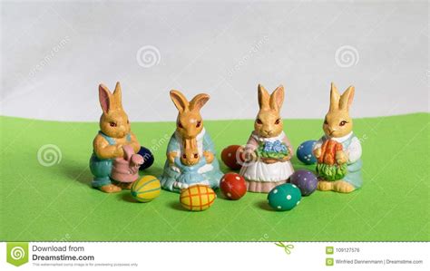Four Easter Bunnies Child`s With Eggs On Green Meadow Stock Photo