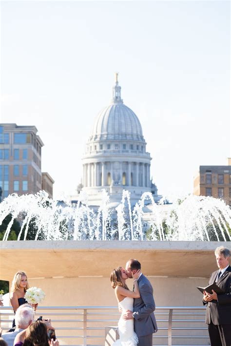 A Bride And Groom Kiss In Front Of The Capital Building During Their