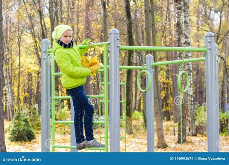 Belle Fille Dadolescent Dans La Chemise Verte Plaing Sur Le Terrain De Jeu Dans Un Parc D