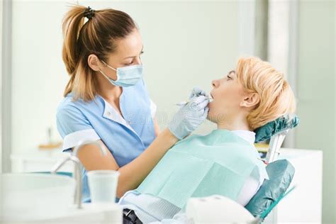 O Dentista Verifica Os Dentes De Uma Menina No Escritrio Dental Imagem