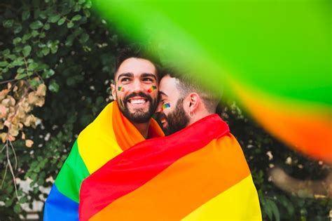 Free Photo Gay Couple With Rainbow Flag Embracing On Street