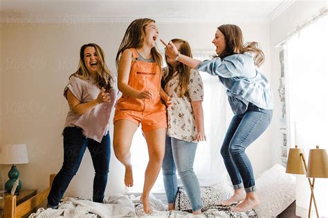 Female Roommates Jumping On The Bed By Stocksy Contributor Erin Drago Stocksy