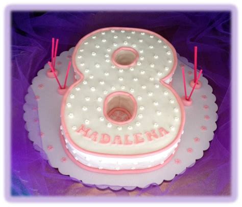 A White And Pink Birthday Cake With The Number Eight On It