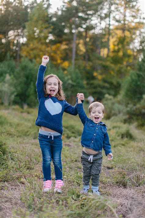 Cute Brother And Sister Holding Hands And Laughing By Stocksy