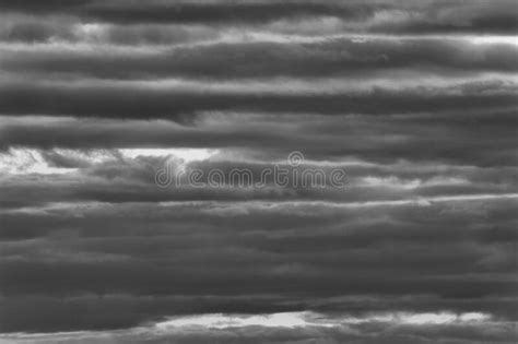 Heavy Wall Of Rain Clouds Under Sunlight As Monochrome Stock Photo