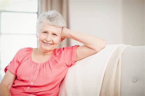 Photodune 15042273 Happy Senior Woman Sitting On Sofa In Living Room