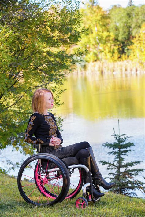 Young Disabled Woman In A Wheelchair In A City Park In Autumn Edmonton
