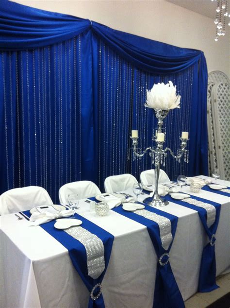 Head table with royal blue back drop and crystal step curtains | Royal