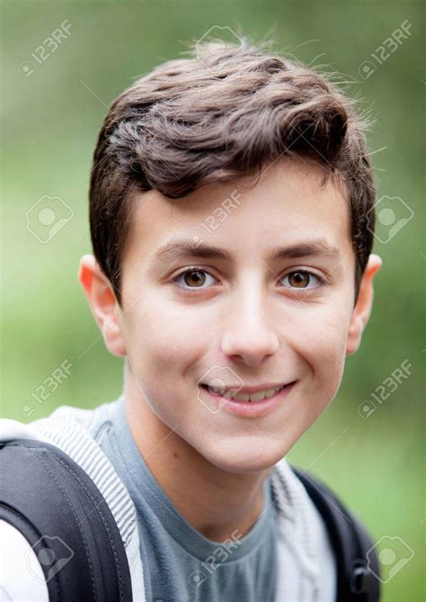 Hermoso adolescente mirando la cámara y sonriendo al aire libre Foto de