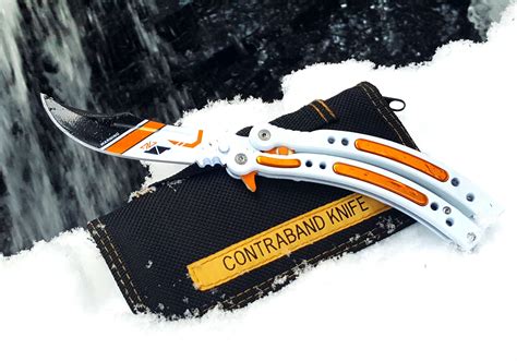 An Orange And White Knife On Top Of Snow