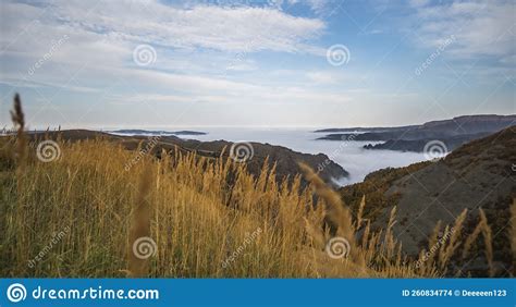 Fog And Clouds Creep Along The Bottom Of The Valley And Mountain Hills