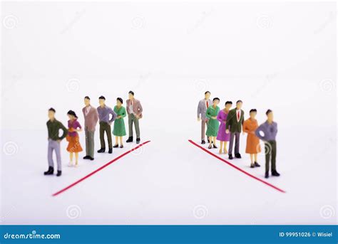 Miniature People In Two Lines Across To Each Other Over White Ba Stock