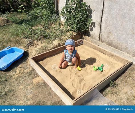 Beautiful Baby In Child Sandpit Posing Photographer Near Sandbox Stock