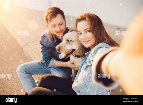 Happy Beautiful Couple Is Having Fun With Labrador Dog Retriever