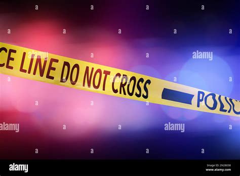 Yellow Law Enforcement Tape Isolating Crime Scene Blurred Background With Red And Blue Police