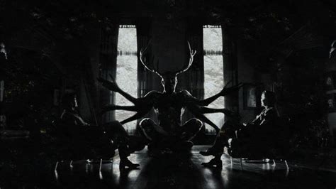 A Group Of People Sitting In Front Of A Window With Large Antlers On It