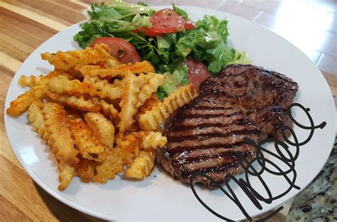 Steak Fries And Salad On A White Plate