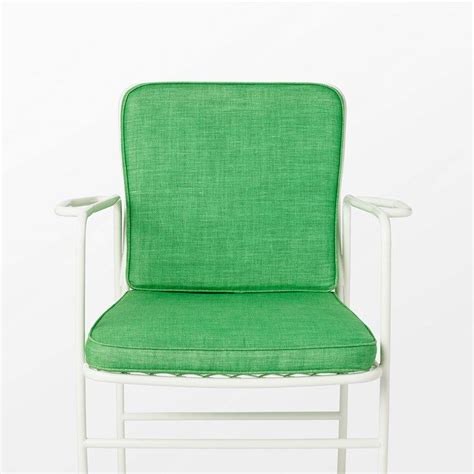 A Green Chair Sitting On Top Of A White Table