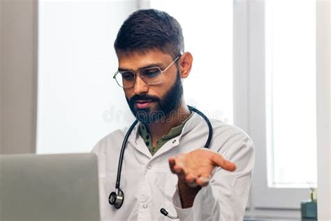 Portrait Of Indian Man Doctor Talking To Online Patient On Laptop