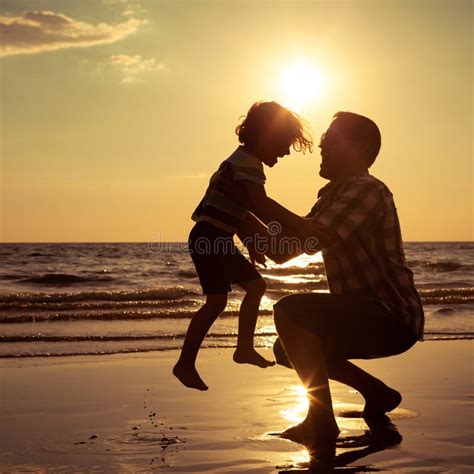 father and son playing on the beach at the sunset time stock image image of sunrise couple
