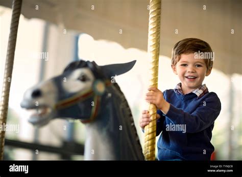 Young Boy Riding Carousel At Carnival Stock Photo Alamy