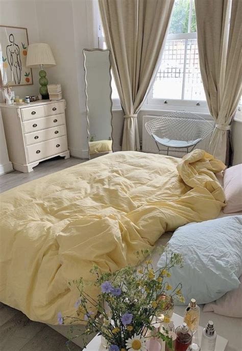 a bed with yellow sheets and pillows in a bedroom