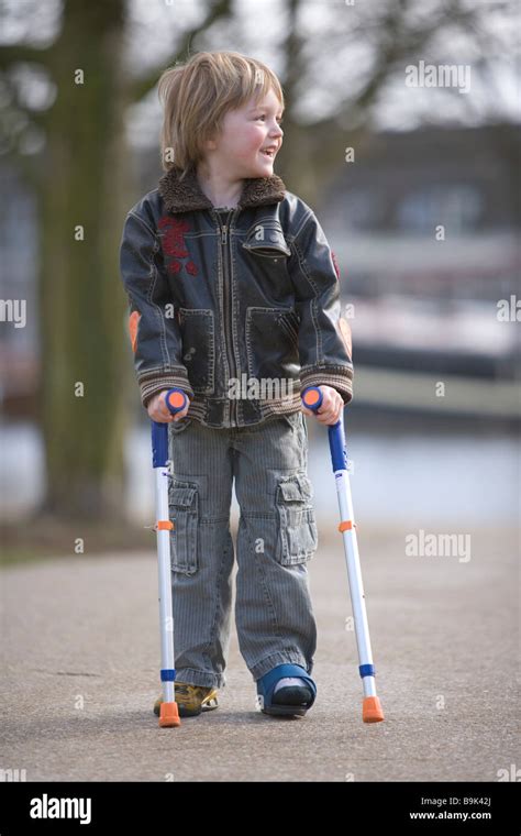 Little Boy With A Broken Leg Walking With Crutches Stock Photo