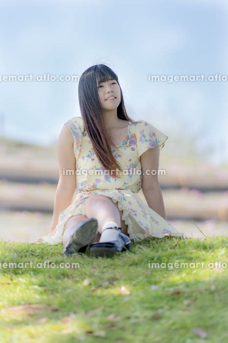 木陰で芝生に座る女性の写真素材 [110255892] イメージマート