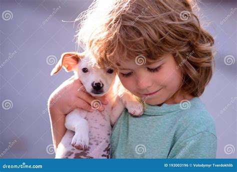 Happy Child And Dog Hugs Her With Tenderness Smiling Little Boy