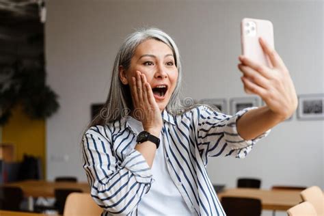 Shocked White Haired Mature Woman Taking Selfie Photo On Cellphone