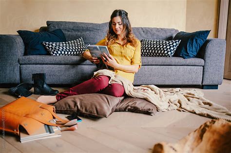 Woman Sitting On The Floor And Reading A Magazine By Lumina Stocksy United