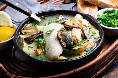 Seafood Fish Soup In Clay Bowls Served With Lemon And Coriander