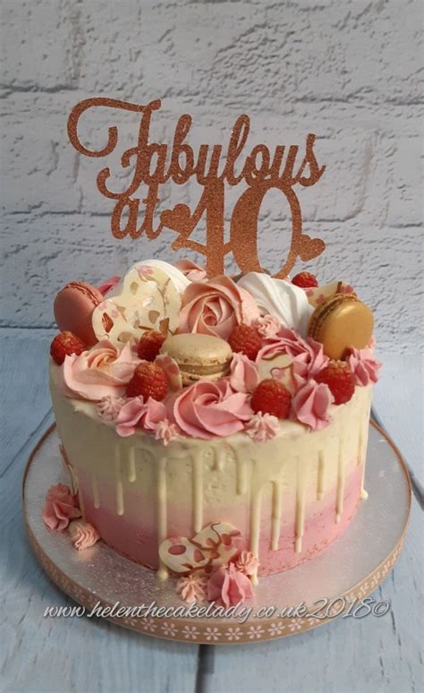 A Birthday Cake With Pink Frosting And Decorations On Top That Says