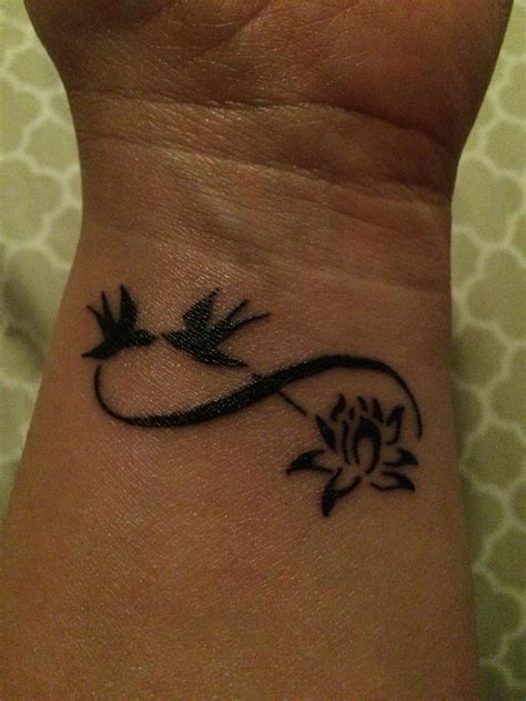 Tattoo Of Infinity Symbol Adorned With Swallows And A Lotus Flower