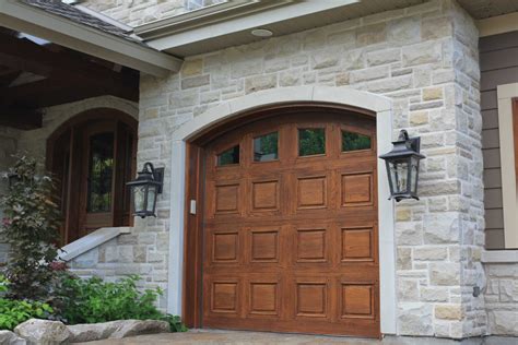 Traditional Wooden Garage Doors And Coach Lights Enhance This Weathered