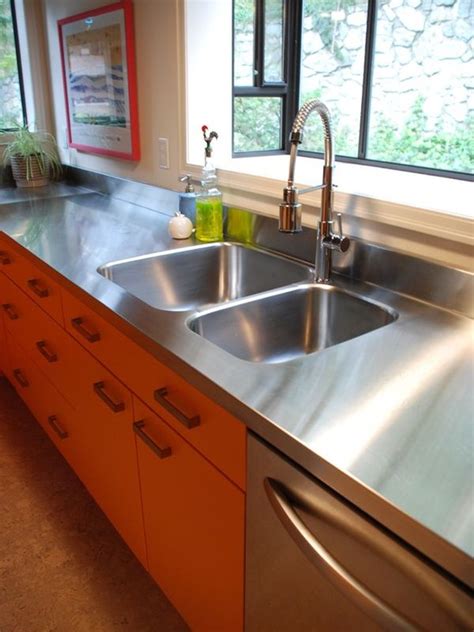 Stainless steel countertops in a white kitchen with warm details. Stainless steel countertops - always the best choice in ...
