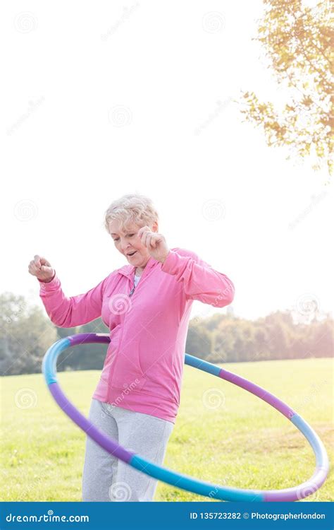 Active Senior Woman Hula Hooping In Park Stock Photo Image Of