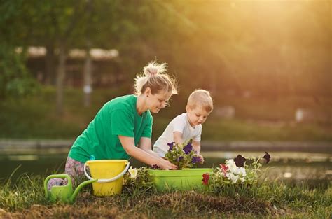Premium Photo Caring For Nature Mother And Son Planting Seedling In