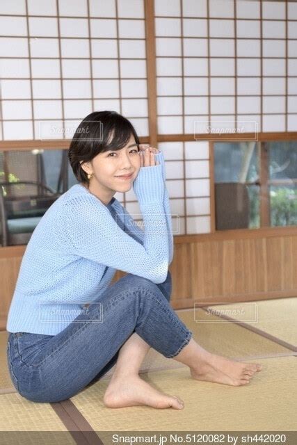 畳の上に座りくつろぐ水色のセーターを着た微笑む若い女性の写真画像素材 5120082 Snapmartスナップマート