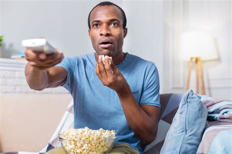 Premium Photo Nice Astonished Handsome Man Eating Popcorn And Being