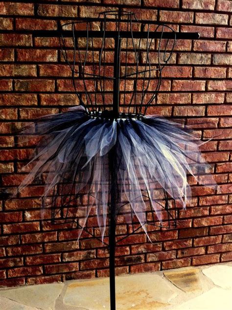 There Is A Blue And White Tutu Skirt Hanging From A Black Metal Stand