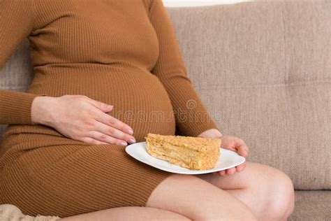 Close Up Of Hungry Pregnant Woman Is Eating A Piece Of Tasty Cake
